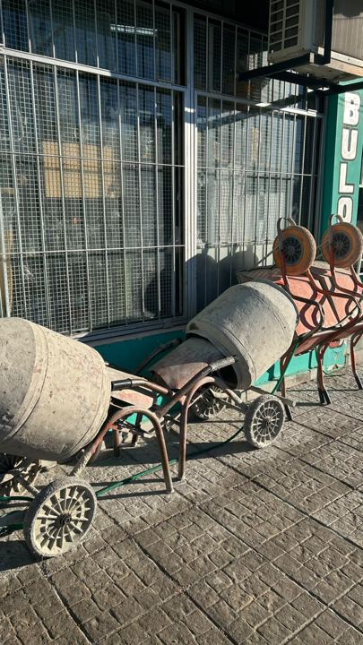 Mezcladoras y carretillas en la vereda